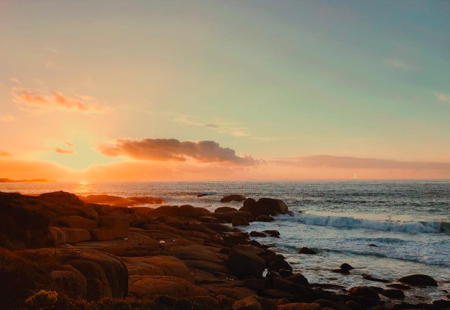 Sunset over the rocky beachfront in Llandudno, Western Cape, South Africa