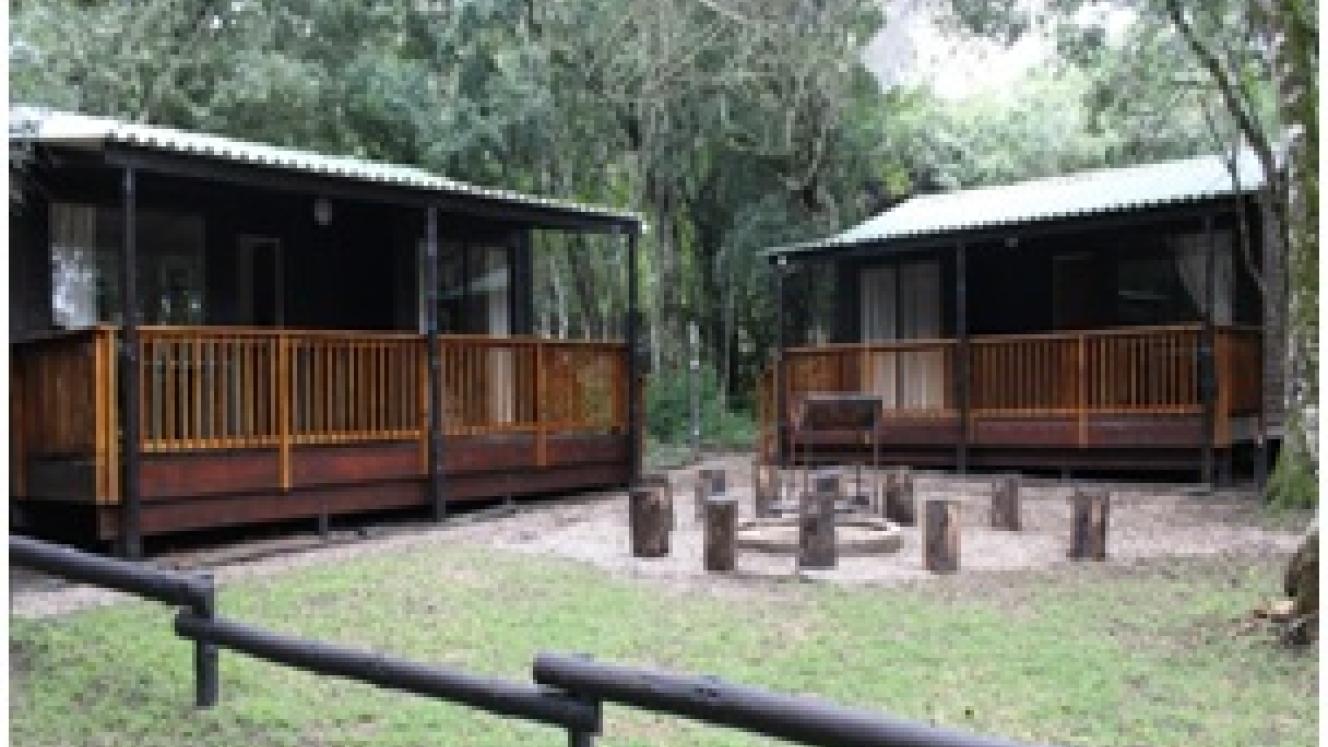 The Langebos Huts offer views of the forest and a communal braai area.