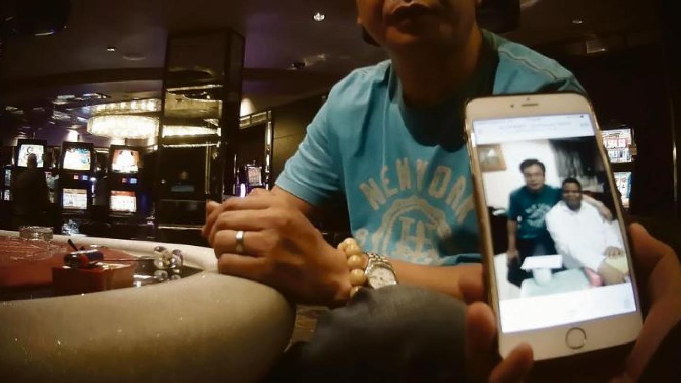 Guan Jiang Guang shows a photo of himself with a man who appears to be Minister of State Security, David Mahlobo.