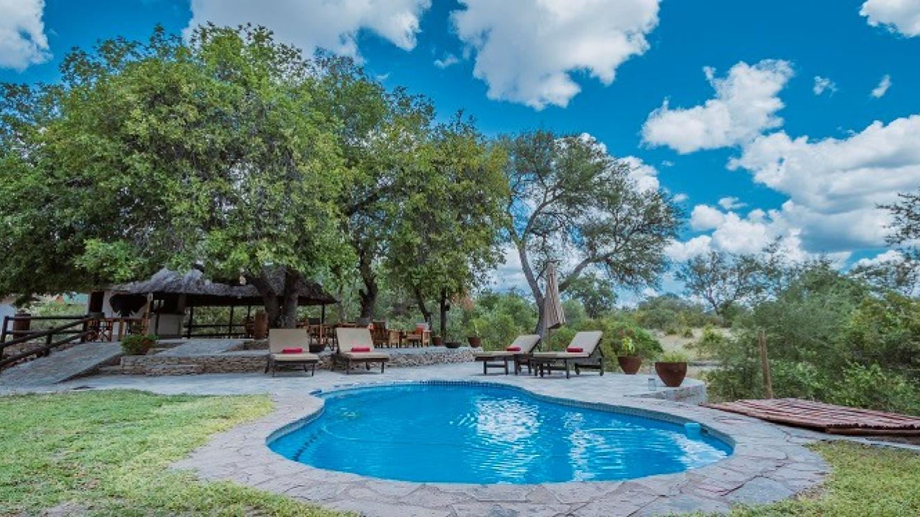 The swimming pool area of Ku Sungula Safari Lodge overlooks the dry riverbed and an active waterhole. 