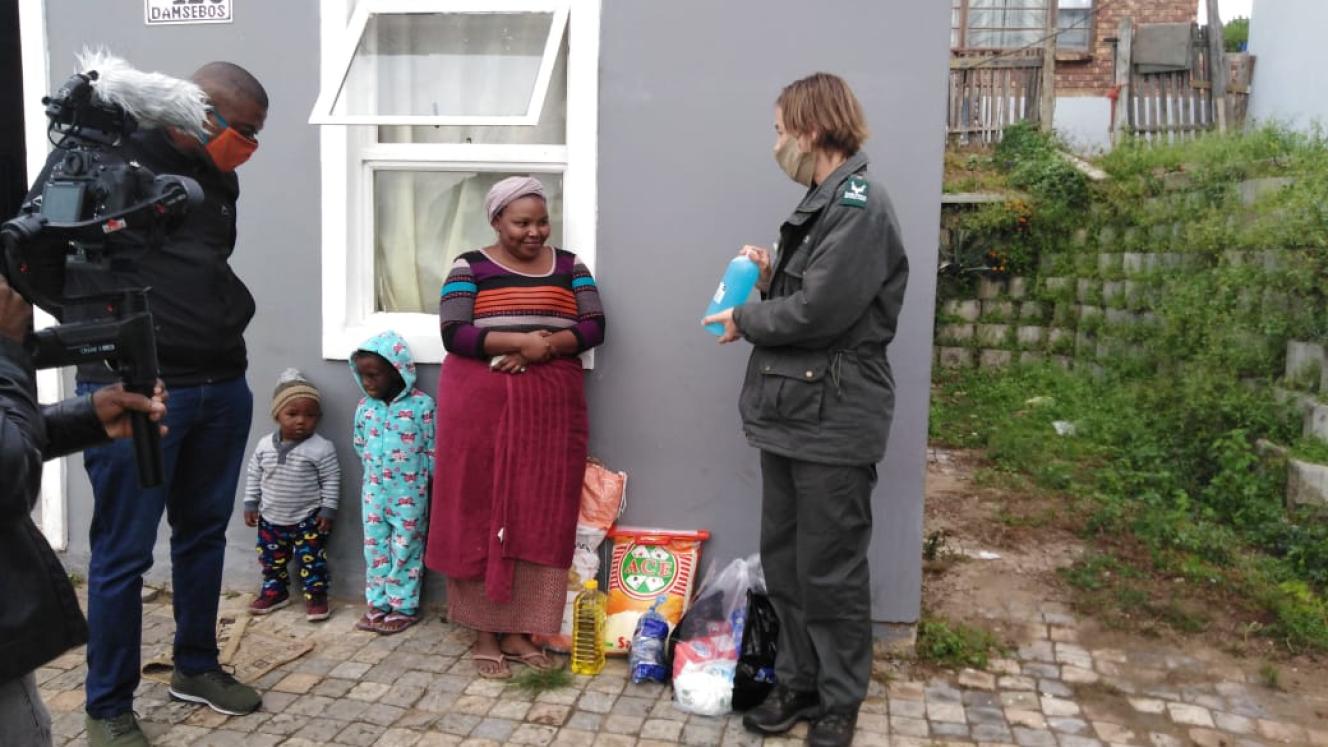 Deputy Mayor, Aubrey Tsengwa and Park Manager for Knysna, Megan Taplin, with the first recipient to receive groceries in Dam se Bos.