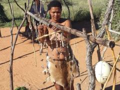 Khomani San woman creating beadwork using local materials. 