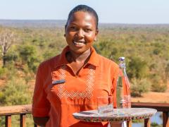 Waitress Kudakwashe Ruwuya serves water in one of the re-usable glass bottles.